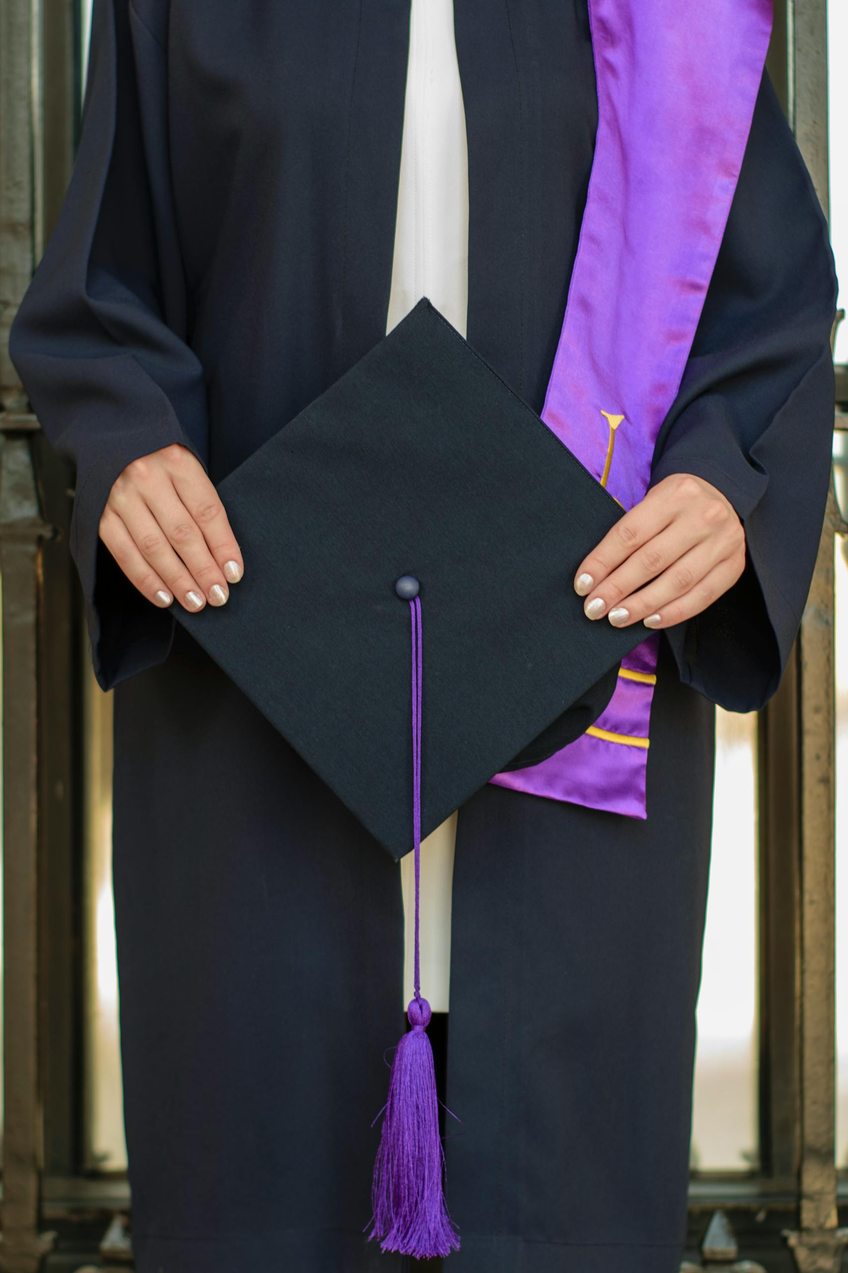 Close-up of a graduate holding a cap, symbolizing academic achievement at a ceremony.