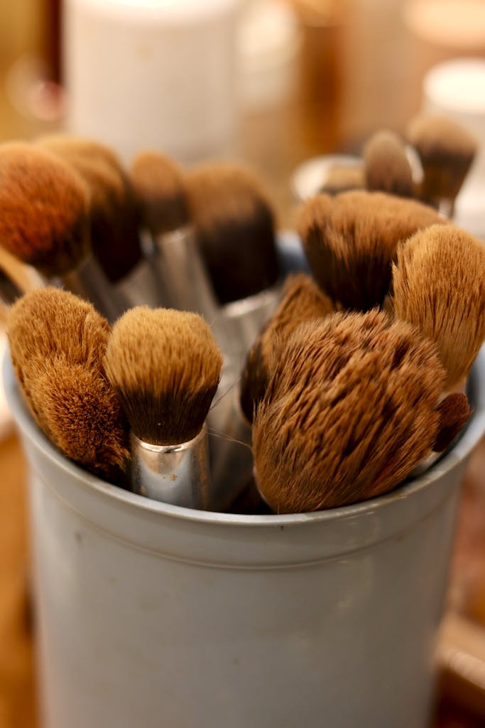 A collection of makeup brushes in a cylindrical holder, perfect for beauty and fashion visuals.